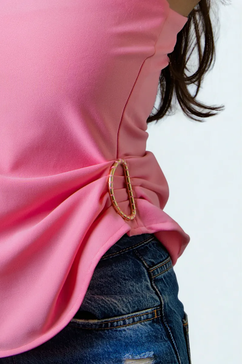 A gathered pink sleeve caught with a gold ring